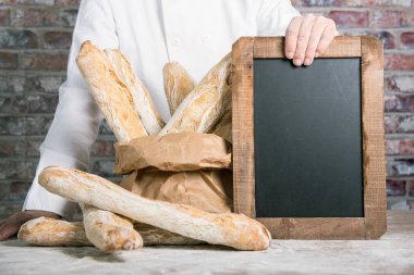 Kara tahta ile Fransız baget ekmek tutan baker