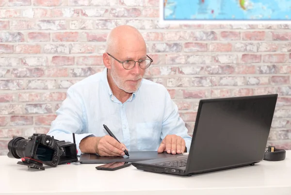 Hombre trabajando en su tableta gráfica y portátil — Foto de Stock