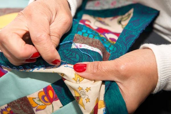 Vrouw naaien voor afwerking een quilt. — Stockfoto