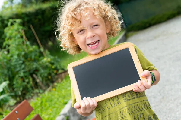 Bir kara tahta tutan küçük sarışın çocuk — Stok fotoğraf