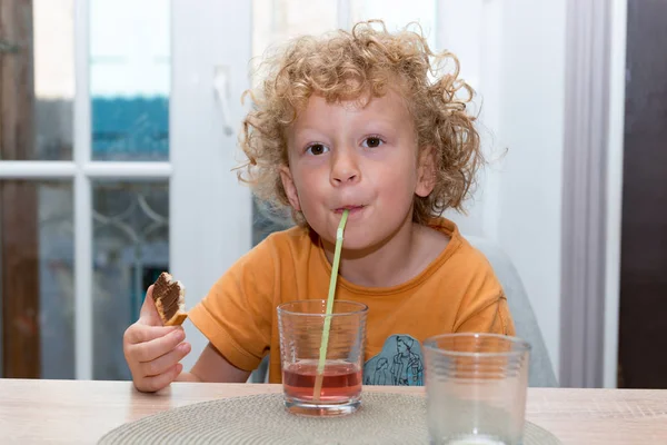 Söt liten pojke dricka röd saft med sugrör — Stockfoto