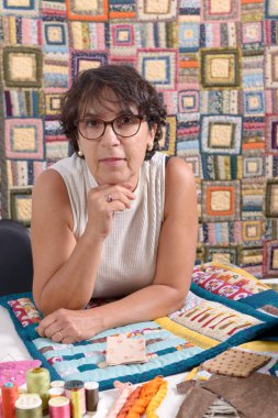 mature brunette woman sewing patchwork clipart