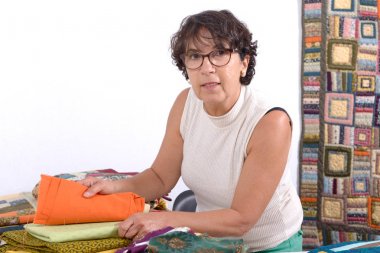 Seçili olgun esmer kadın kumaş patchwork için dikiş