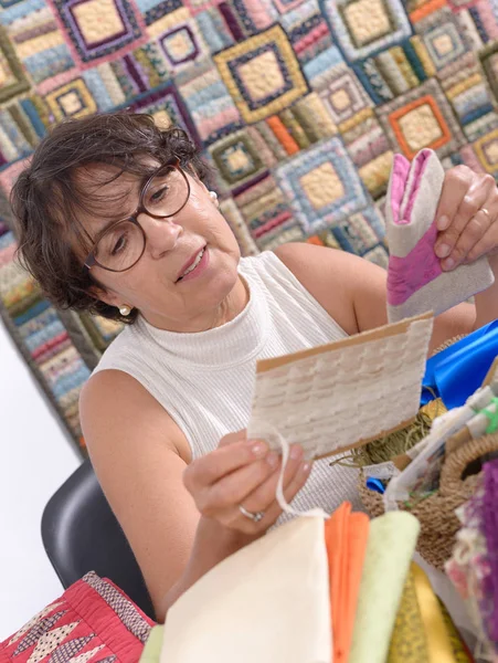 Mature brunette woman sewing patchwork — Stock Photo, Image