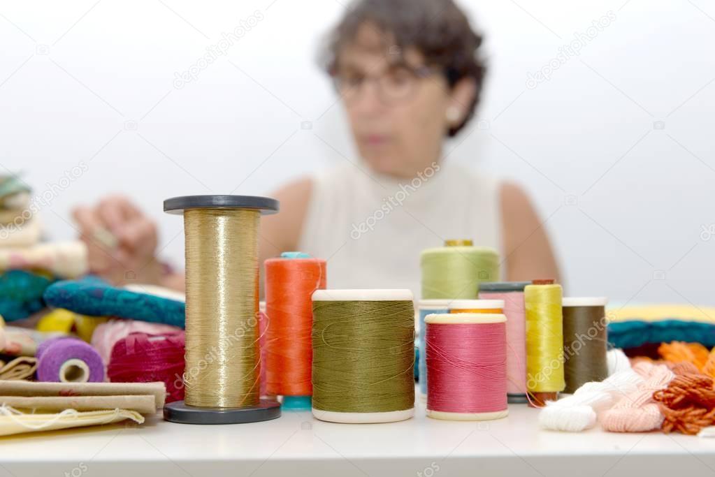 reels of colored threads, seamstress at the bottom