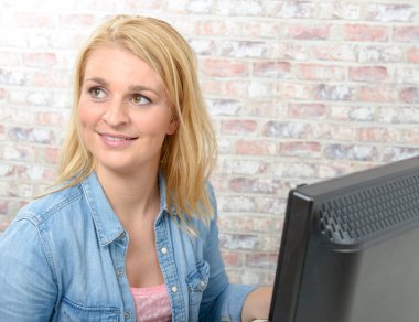 Bilgisayarda çalışan genç bir kadın. 