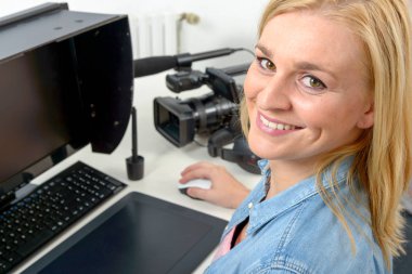 Tablet kullanarak bilgisayarda çalışan genç grafik tasarımcı