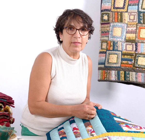 Mature brunette woman sewing patchwork — Stock Photo, Image