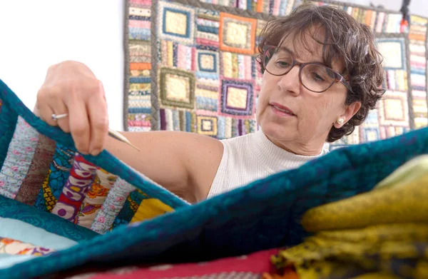 Mature brunette woman sewing patchwork — Stock Photo, Image