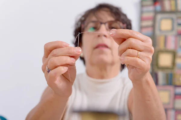 Seamstress threading a needle — Stock Photo, Image