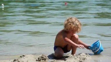  Kumsalda oynarken küçük sarışın çocuk