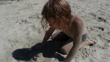  Kumsalda oynarken küçük sarışın çocuk