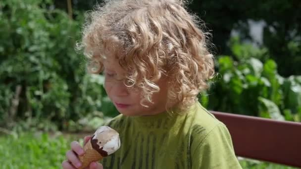 Pequeño chico rubio comiendo un helado — Vídeos de Stock