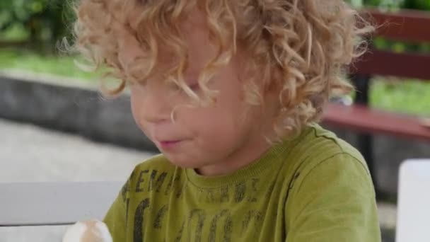 Küçük sarışın çocuk bir dondurma yemek — Stok video