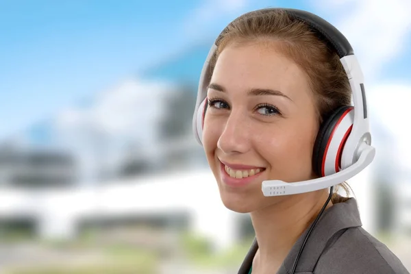 Bela jovem sorridente com um fone de ouvido — Fotografia de Stock