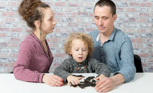 Happy family playing dominos — Stock Photo, Image