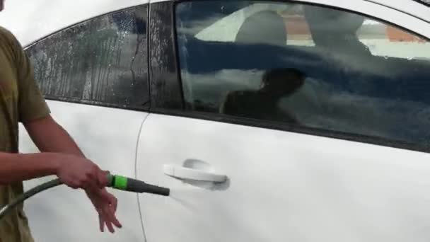 Een jonge man het wassen van de auto — Stockvideo