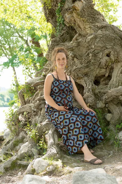 Красивая беременная женщина сидит под деревом — стоковое фото
