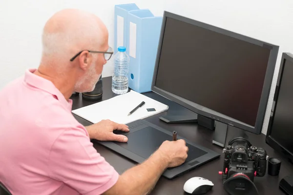 Uomo maturo che lavora con tablet grafica nel suo ufficio — Foto Stock