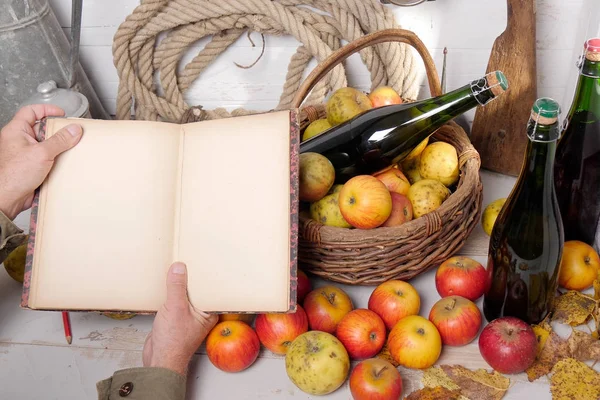 Cesta de manzanas, botellas de sidra y cuaderno viejo — Foto de Stock