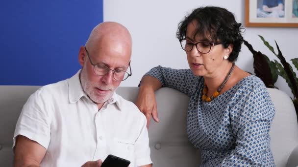年长的夫妇使用智能手机和微笑 — 图库视频影像