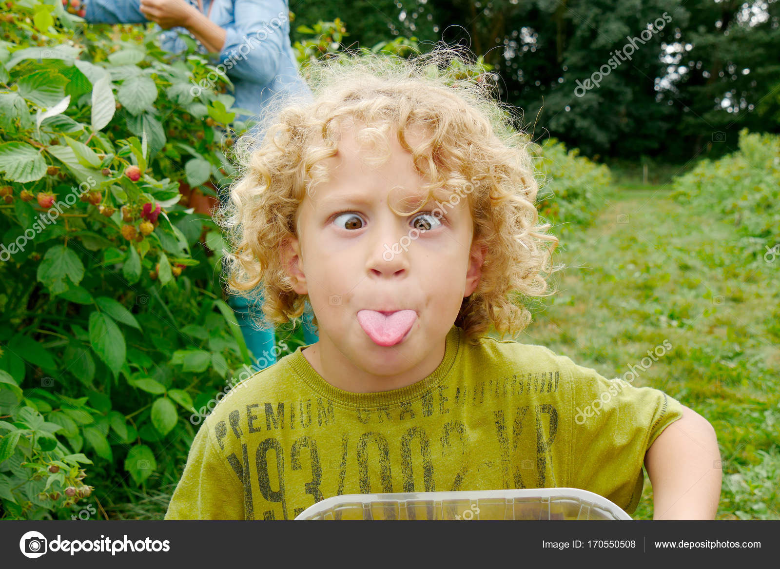 Little Boy With Blond And Curly Hair Making Faces Stock Photo