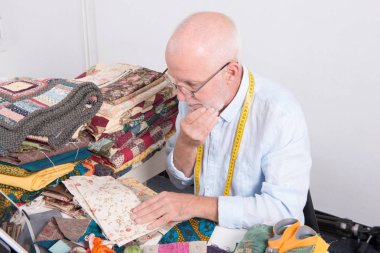 Olgun adam terzi atölyesinde çalışan