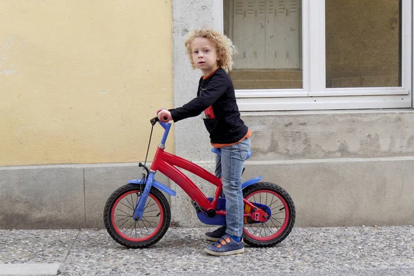 赤い自転車で小さな金髪の少年 — ストック写真