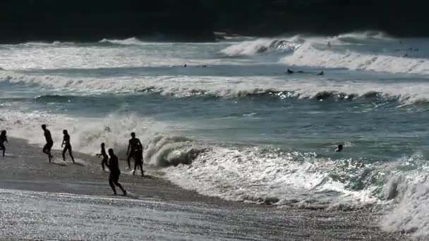 Zwemmers op het strand van Biarritz op zonsondergang, slow-motion — Stockvideo