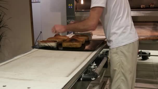 Piekarz zajmuje chleb z pieca — Wideo stockowe