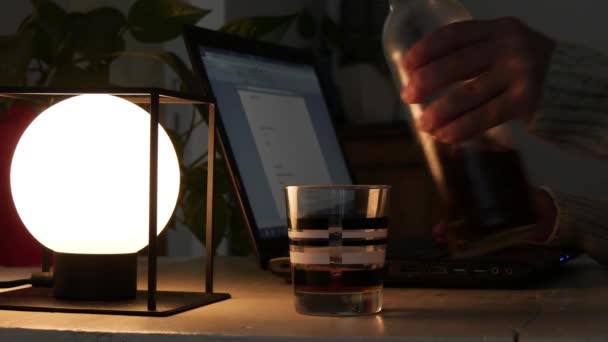 Алкоголик, работающий с ноутбуком и пьющий виски — стоковое видео