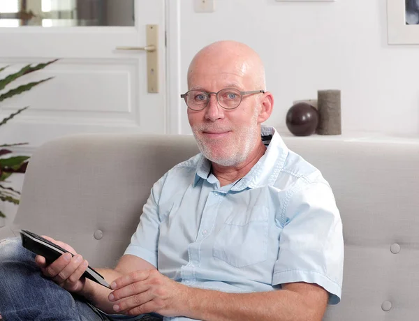 Dojrzały człowiek starszy z niebieską koszulę, oglądanie telewizji — Zdjęcie stockowe