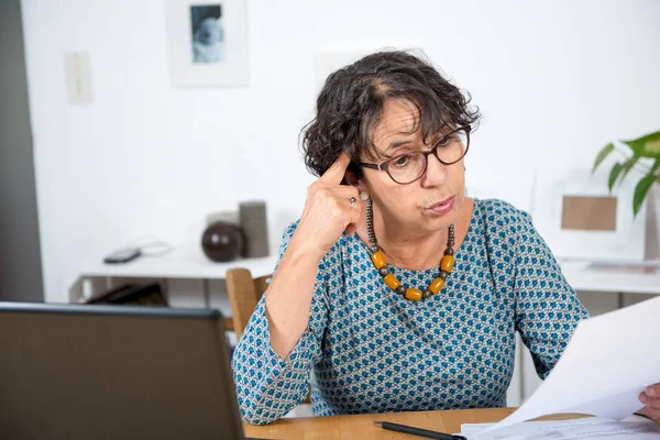 Idősebb nő, kifizető számlák-val laptop otthon — Stock Fotó