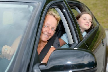 Anne ve kızı arabada gülümseyen