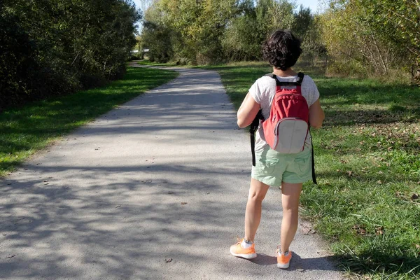 Zadní pohled na ženu tramp s červeným batohem — Stock fotografie