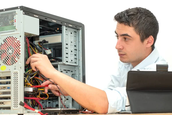 Jeune technicien travaillant sur un ordinateur cassé dans son bureau — Photo