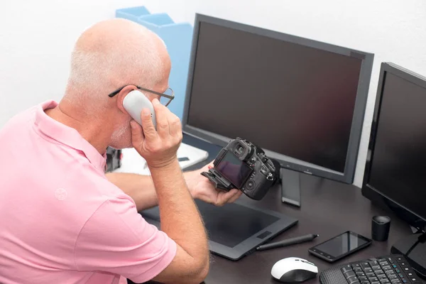 Photographe avec appareil photo au bureau avec ordinateur — Photo