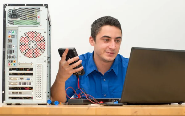 그의 사무실에서 깨진된 컴퓨터에서 작업 하는 젊은 기술자 — 스톡 사진
