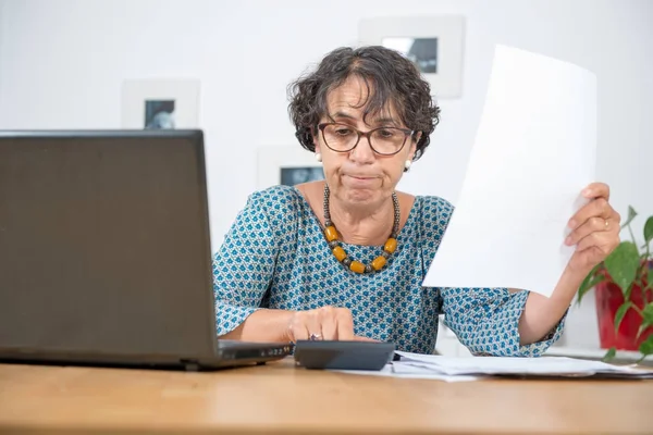 Idősebb nő, kifizető számlák-val laptop otthon — Stock Fotó