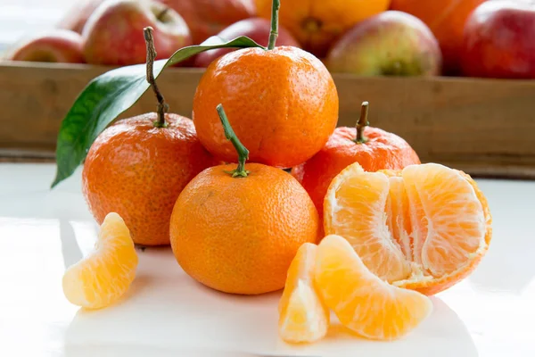 Tangerinas e fatias de tangerina na mesa branca — Fotografia de Stock