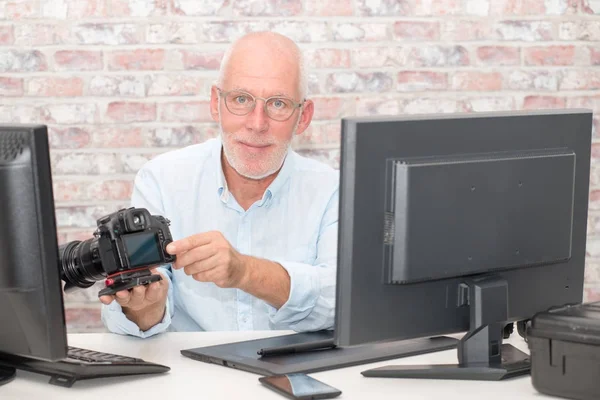 Fotógrafo e câmera no escritório com computador — Fotografia de Stock