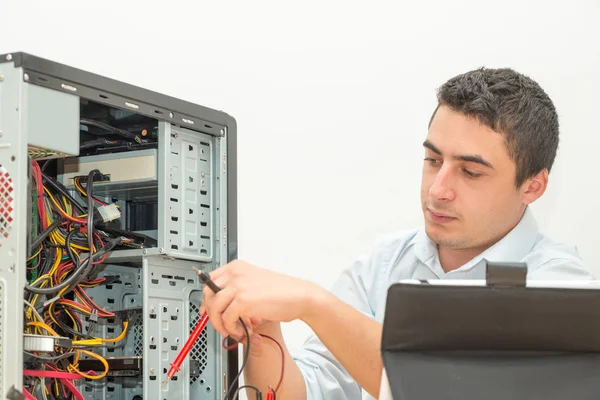 Young technician working on broken computer in his office — Stock Photo, Image