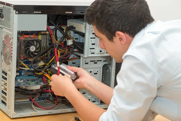 Technik pracující na rozbité počítače ve své kanceláři — Stock fotografie