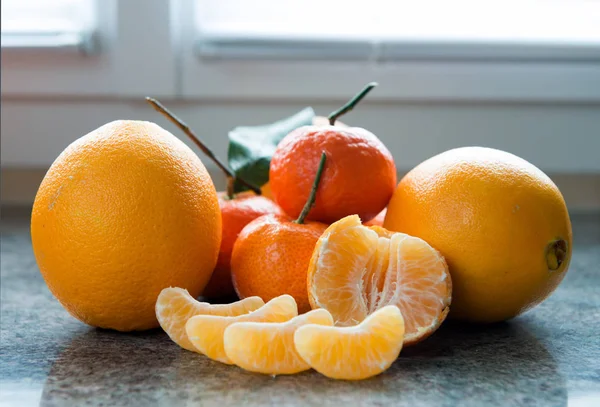 Mandarynki i mandarynki plasterki na stole — Zdjęcie stockowe