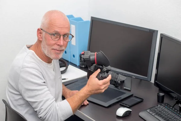 Fotógrafo con cámara en la oficina con ordenador —  Fotos de Stock