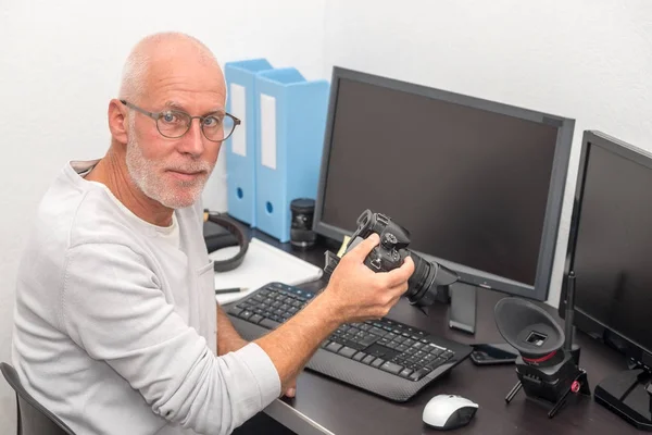 Photographe avec appareil photo au bureau avec ordinateur — Photo