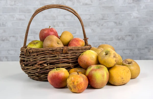 Корзина с яблоками на белом столе — стоковое фото