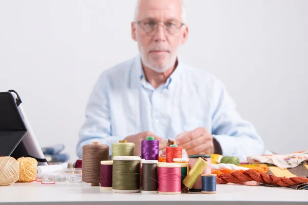 Carretes de hilos de colores, hombre sastre en la parte inferior — Foto de Stock