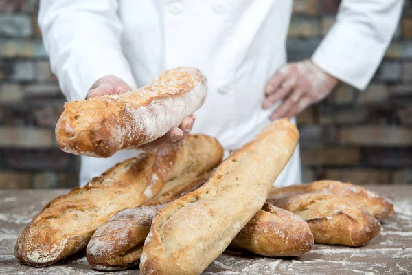 Baker with traditional bread french baguettes — Stock Photo, Image