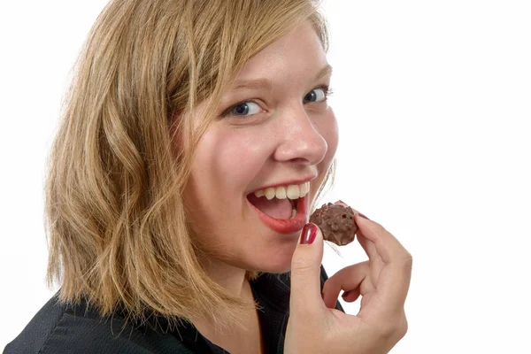 Sonriente joven comiendo chocolate, en blanco —  Fotos de Stock